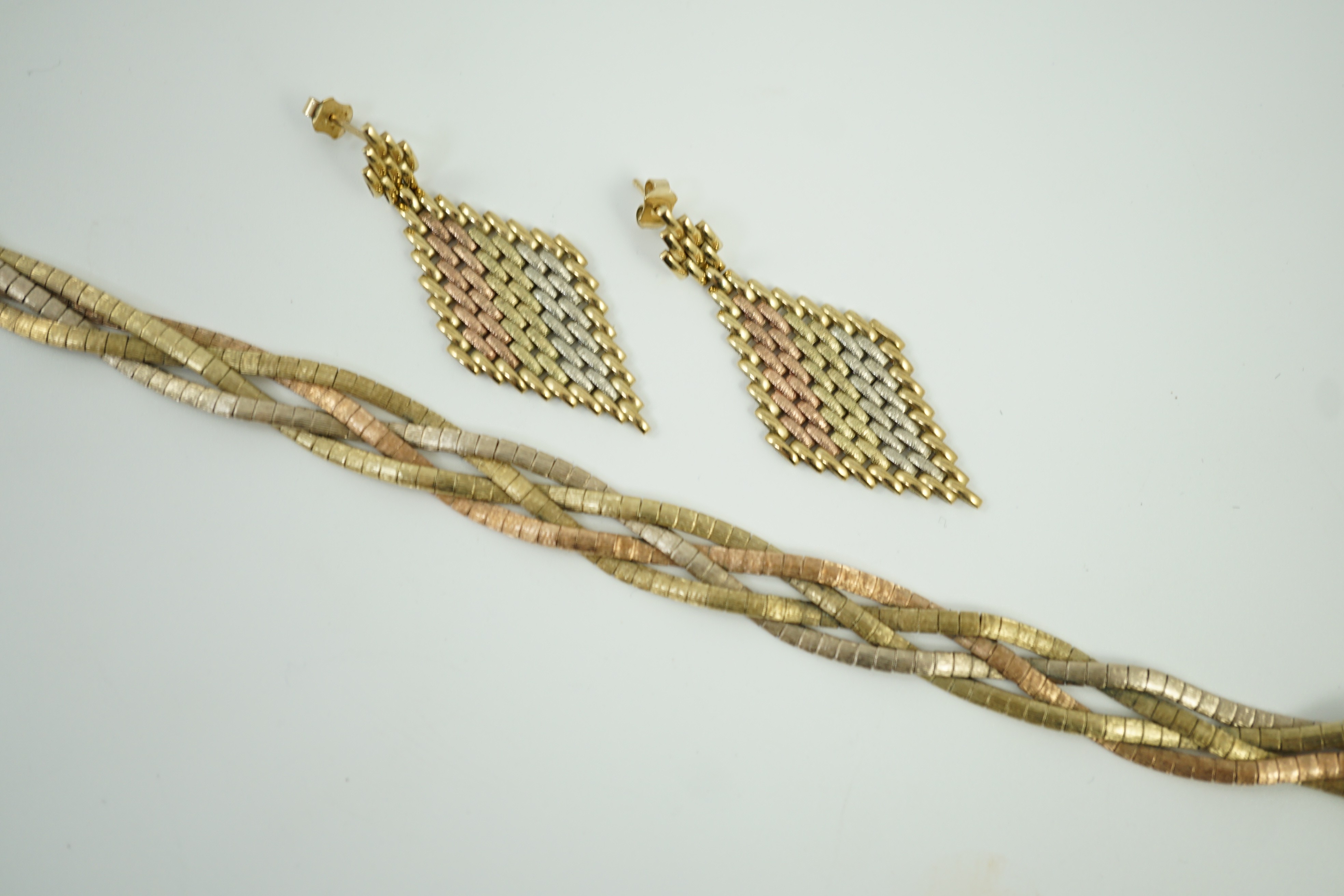 A modern three colour 9ct gold interwoven bracelet, 18.5cm and a pair of similar 9kt drop earrings, 30.6 grams.